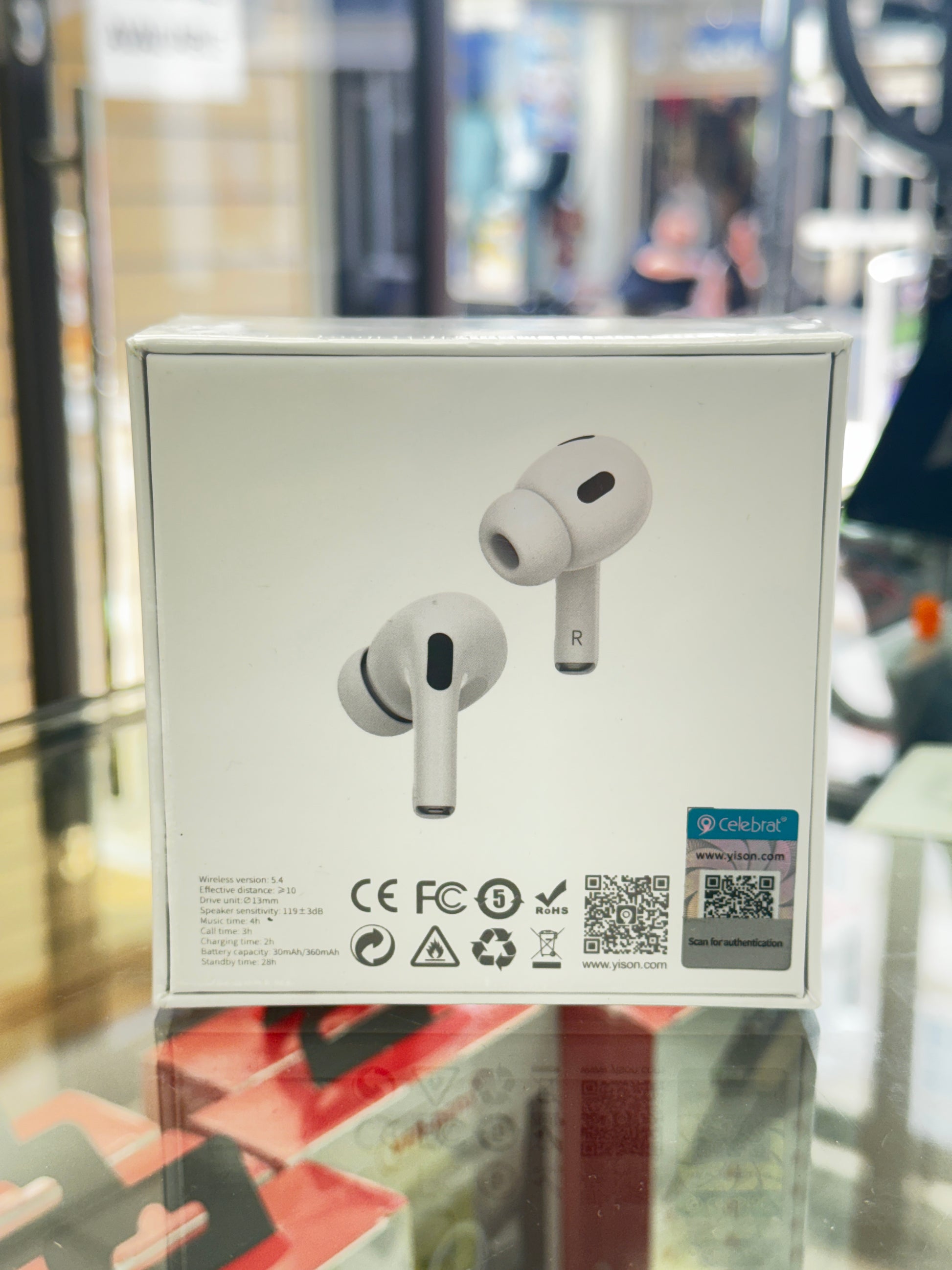Wireless earbuds in a box with a QR code on a glass surface